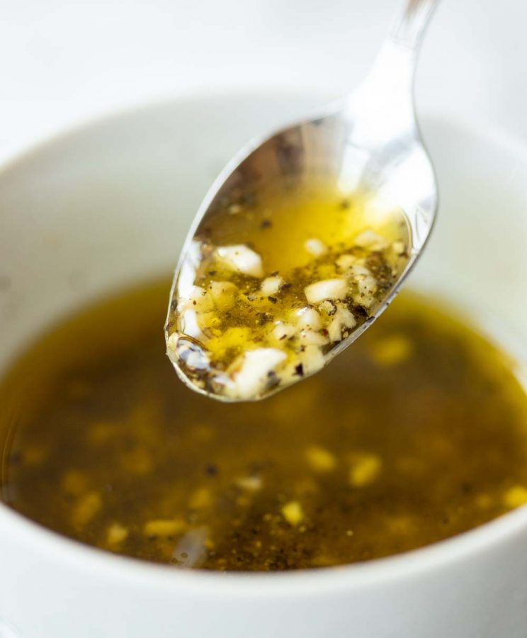 close up shot of teaspoon with oil dripping of it