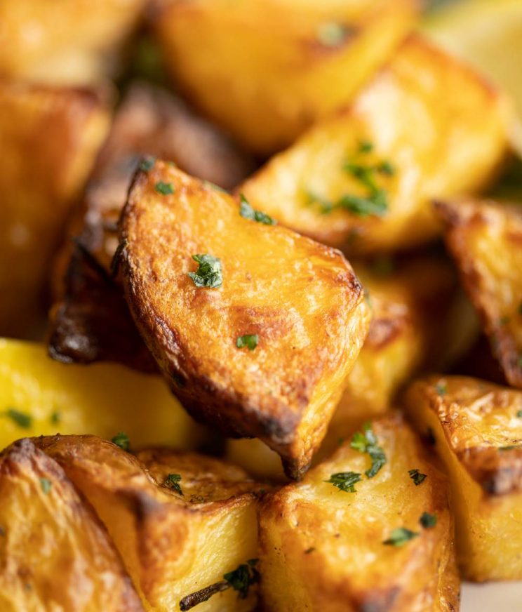 close up shot of potato on baking tray garnished with parsley
