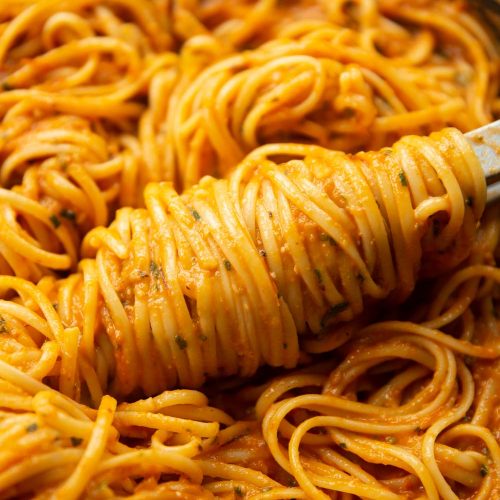 pasta tongs twisting spaghetti in skillet