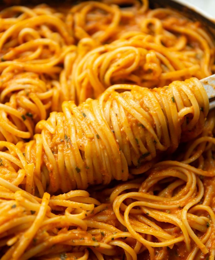 pasta tongs twisting spaghetti in skillet
