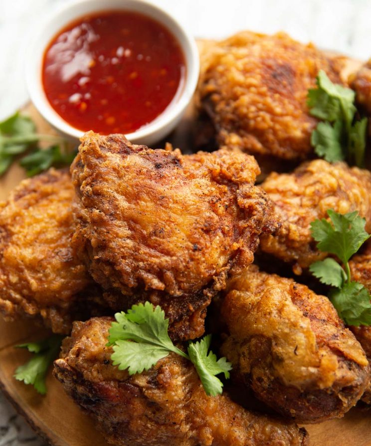 closeup shot of chicken on wooden board with board blurred in background