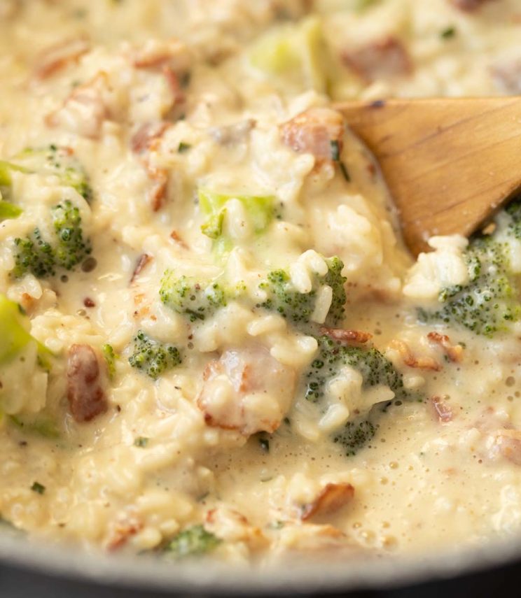 wooden spoon diving into rice in casserole dish
