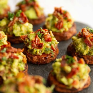 sweet potato bites on slate, focused on one in the middle garnished with coriander