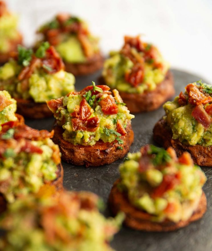 sweet potato bites on slate, focused on one in the middle garnished with coriander