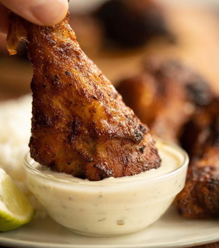 drumstick being dunked into small glass pot of ranch