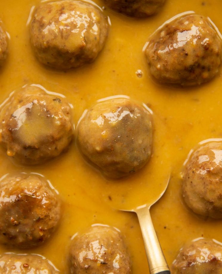 overhead shot of meatballs in gravy with spoon resting underneath one