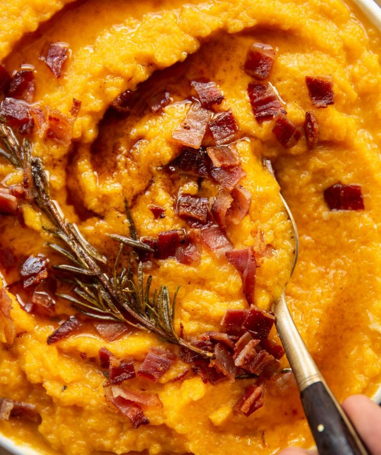 close up overhead shot of gold spoon digging into bowl of mash