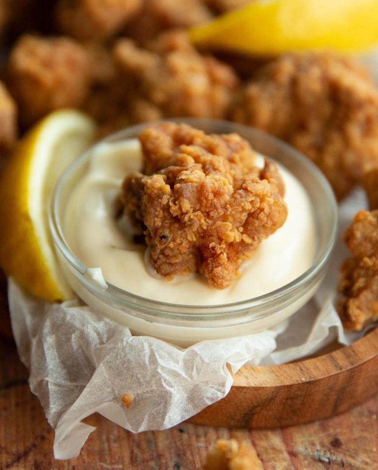 chicken dunked in small glass pot of mayonnaise