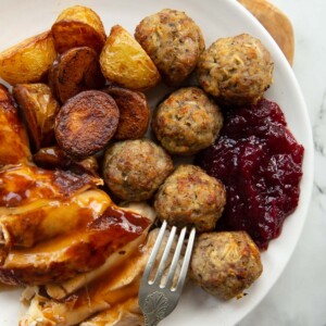 overhead shot of small roast dinner on white plate with stuffing balls