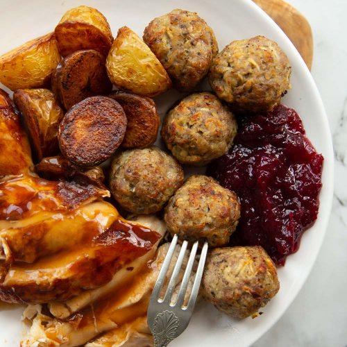 overhead shot of small roast dinner on white plate with stuffing balls