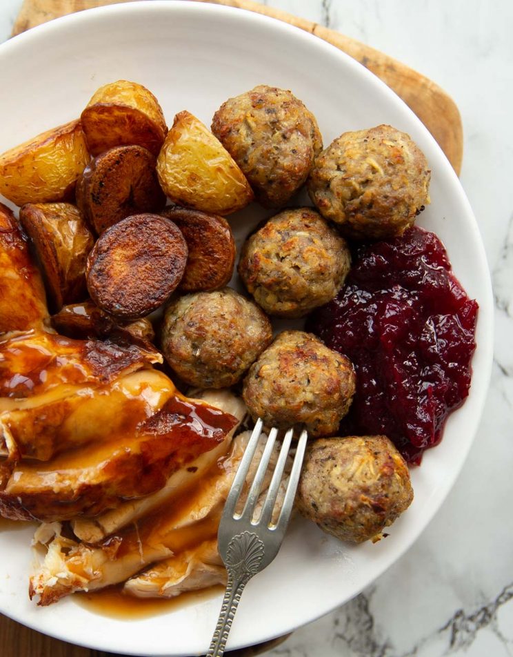 overhead shot of small roast dinner on white plate with stuffing balls