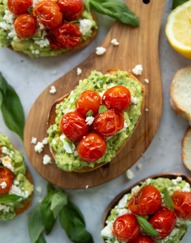 overhead shot of toast on wooden board surrounded by toast and garnish