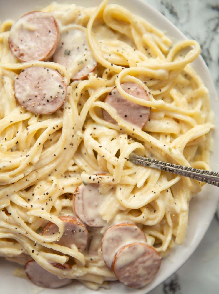 overhead shot of fork digging into plate of pasta