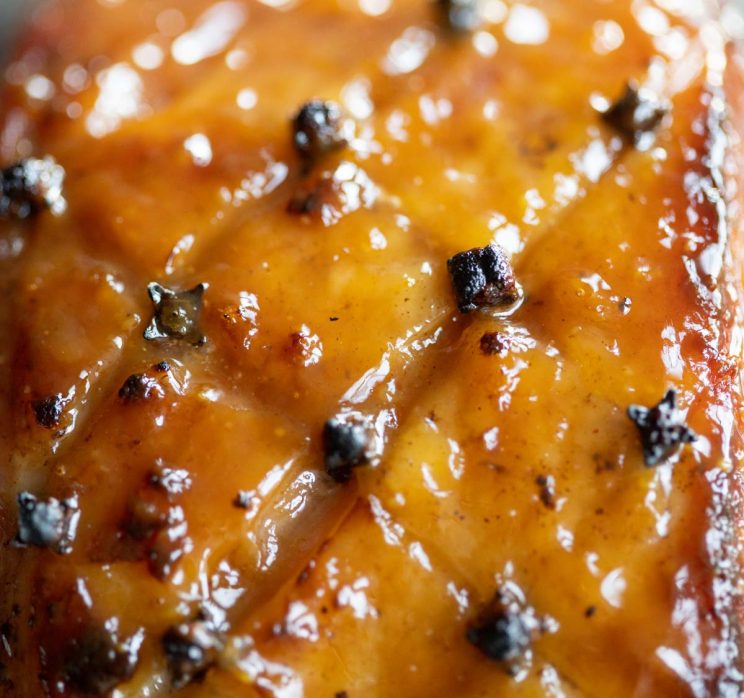 ultra close up shot of glaze on ham with cloves stuck in