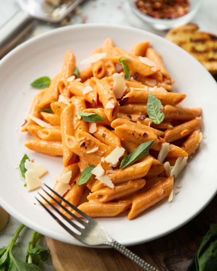 pasta plated up with fresh basil and garnish blurred in the backgorund
