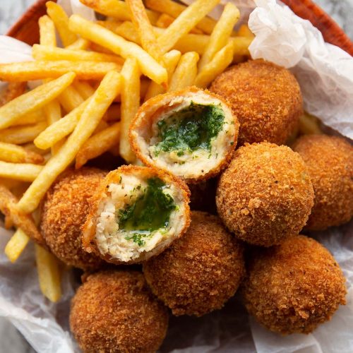 overhead shot of kievs and french fries in small bowl with a kiev split in half on top