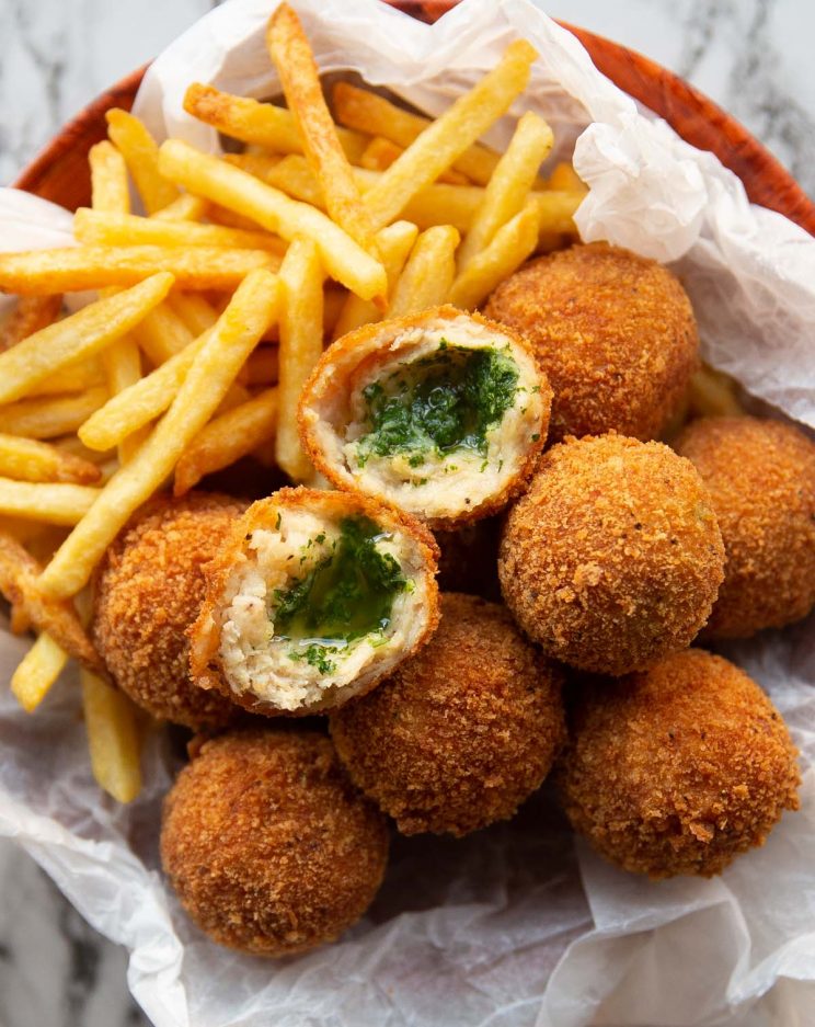 overhead shot of kievs and french fries in small bowl with a kiev split in half on top