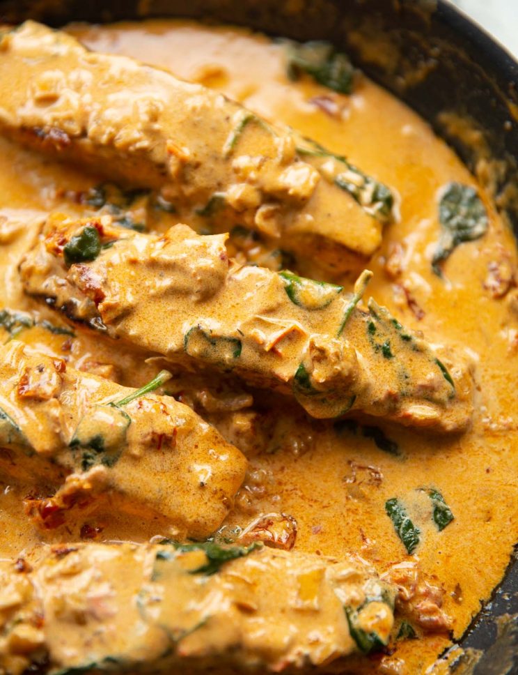 4 salmon fillets in creamy sauce in skillet
