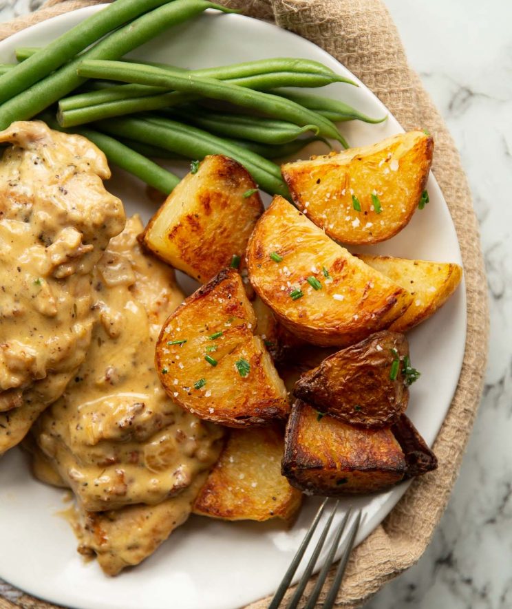 overhead of potatoes served with chicken and green beans