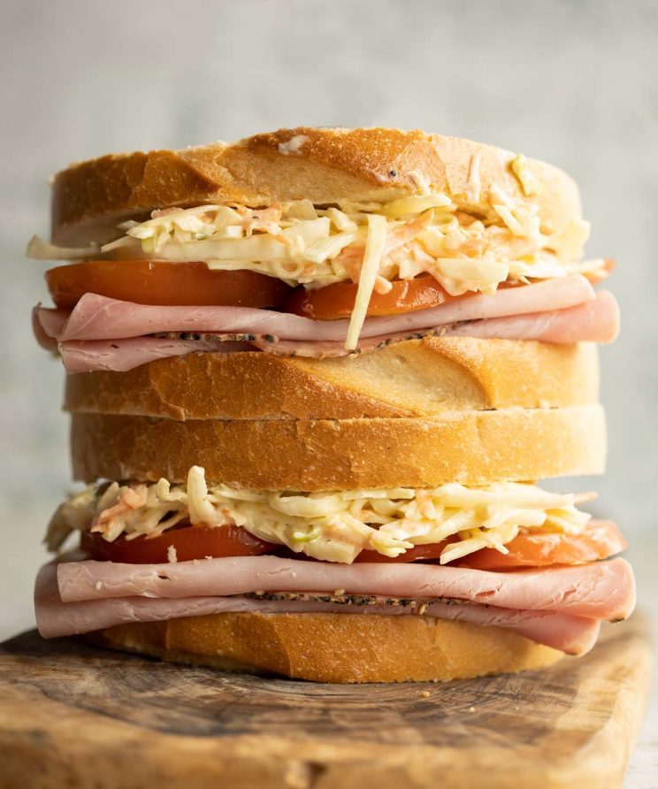 two sandwiches stacked on each other on wooden board
