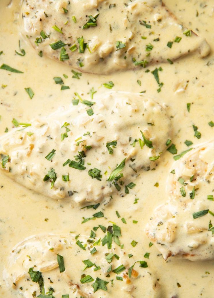 overhead shot of chicken in skillet garnished with tarragon