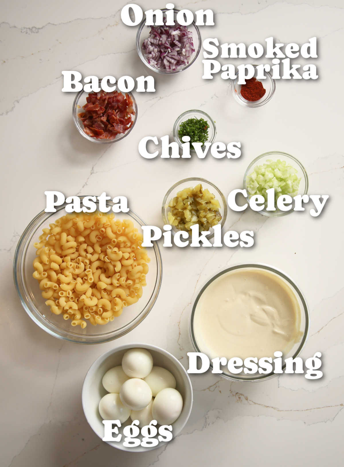 overhead shot of deviled egg pasta salad ingredients with text labels