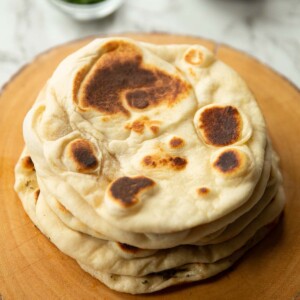 5 flatbreads stacked on each other on wooden board