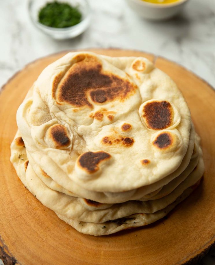 5 flatbreads stacked on each other on wooden board