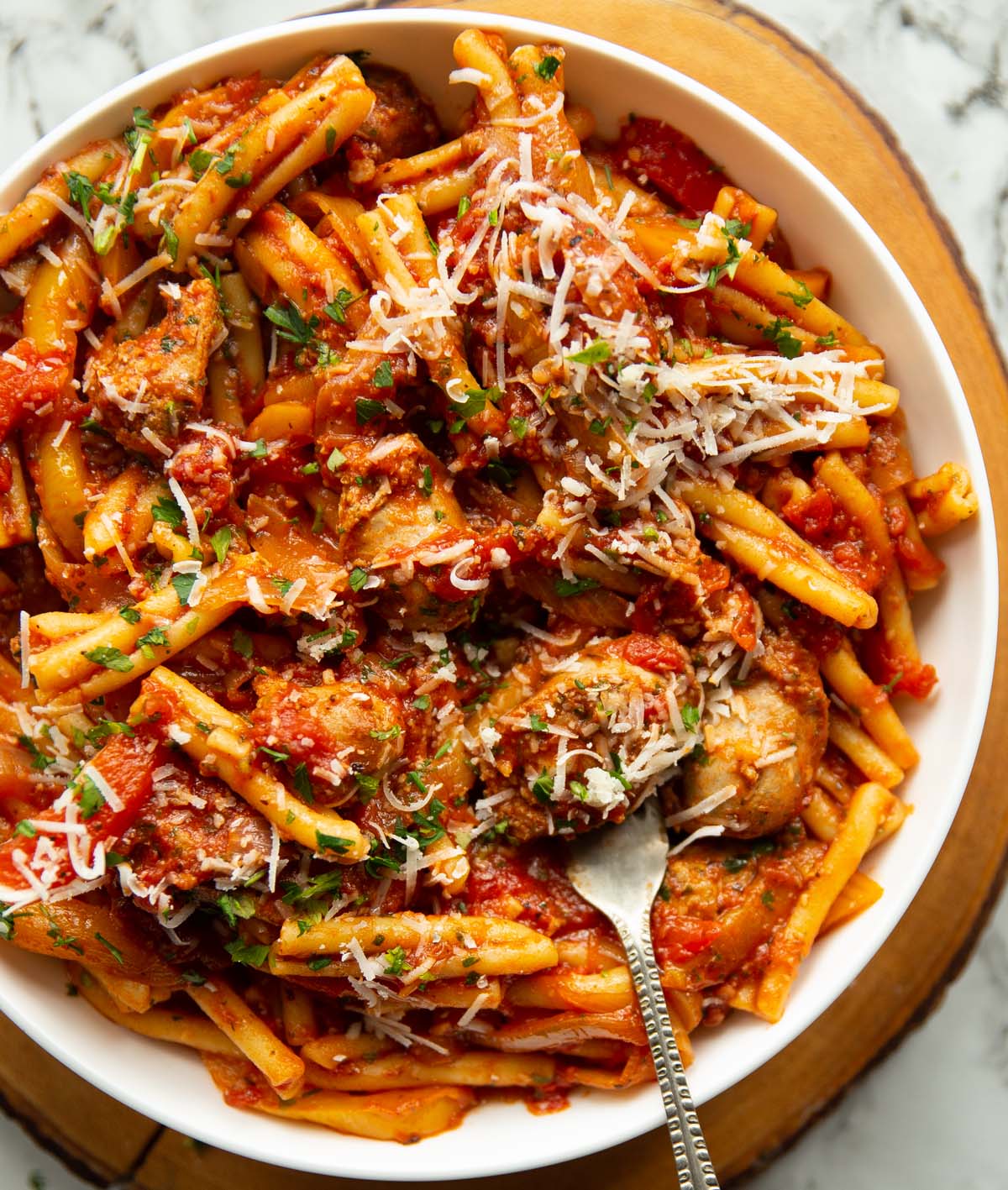 overhead shot of pasta in large white bowl with silver fork digging in
