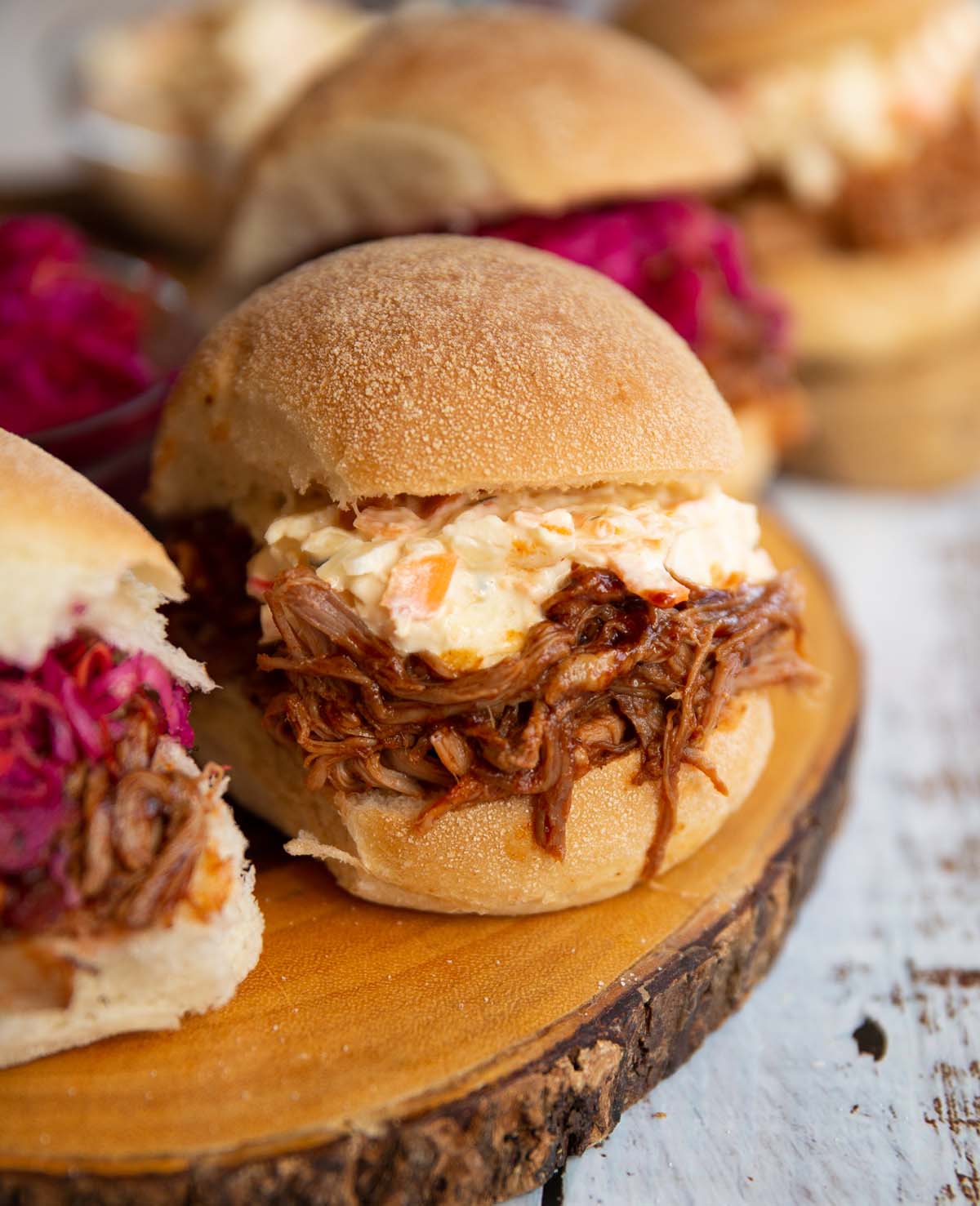 close up shot of pulled pork sandwich on wooden board