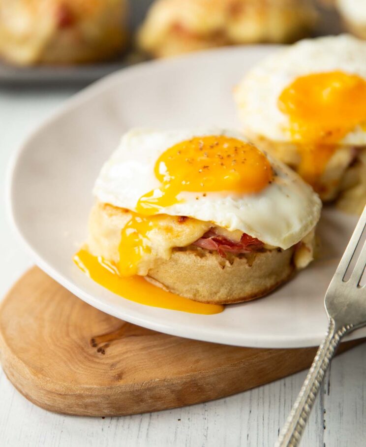 two madame crumpets on white plate on small wooden board with silver fork