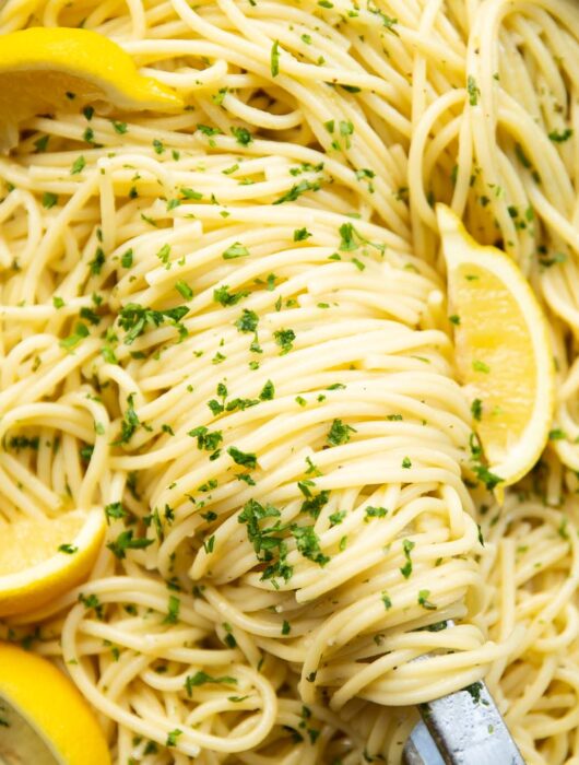 close up overhead shot of lemon pasta and tongs in pan