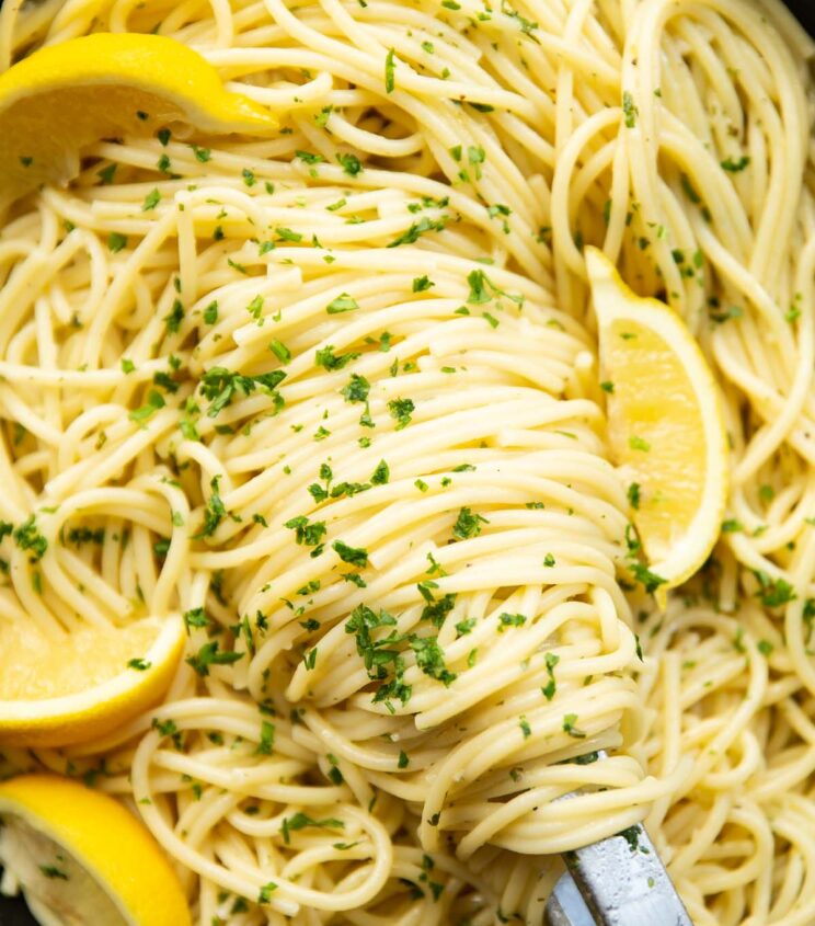close up overhead shot of lemon pasta and tongs in pan