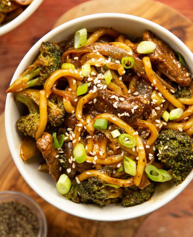 close up over head shot of black pepper beef noodles in small white bowl