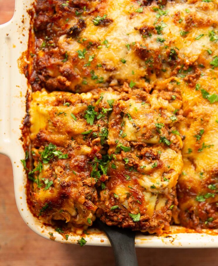 overhead close up shot of spatula digging into ravioli lasagne