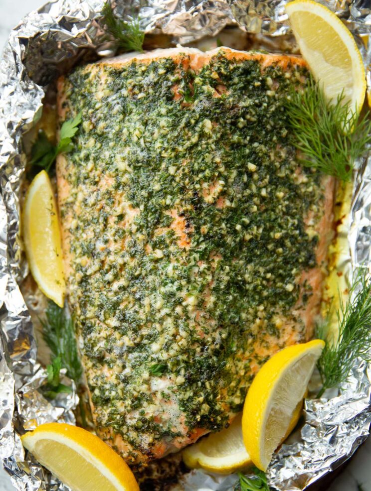 overhead close up shot of salmon wrapped in foil garnished with lemon wedges