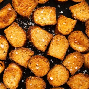 close up overhead shot of bagel chips fresh out the oven on black tray