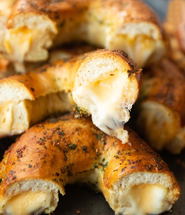 close up shot of halved cheese stuffed bagels on baking tray showing filling