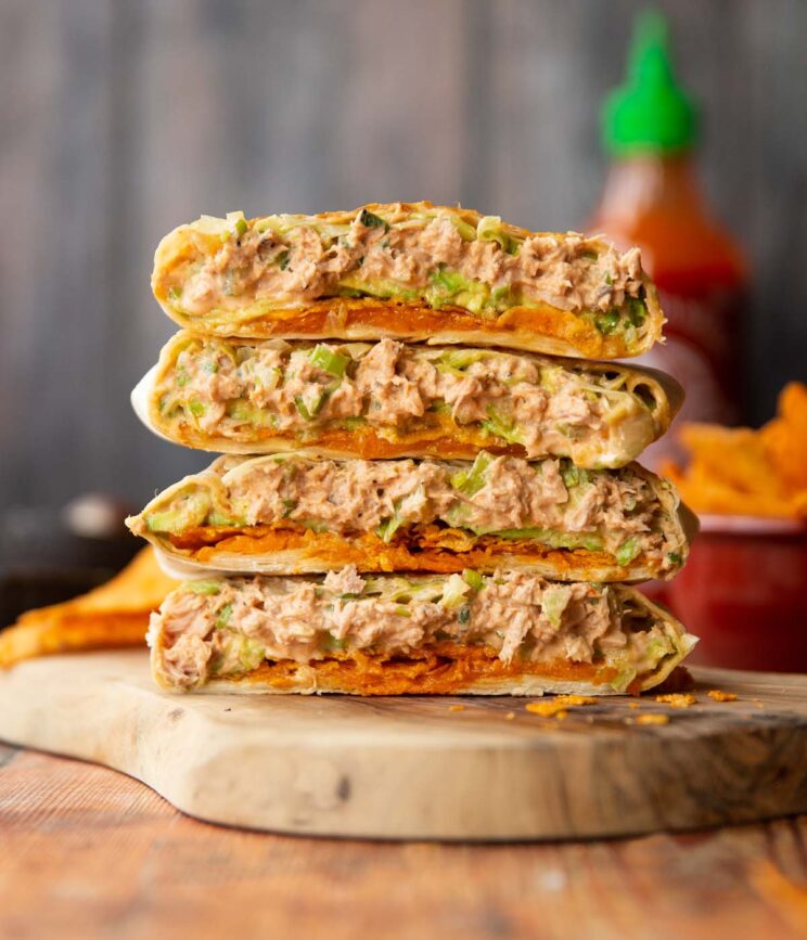 4 crunchwrap halves stacked on each other on wooden board showing filling