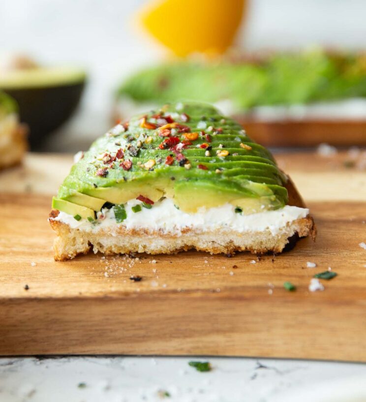 close up shot of half a slice of cream cheese avocado on toast 