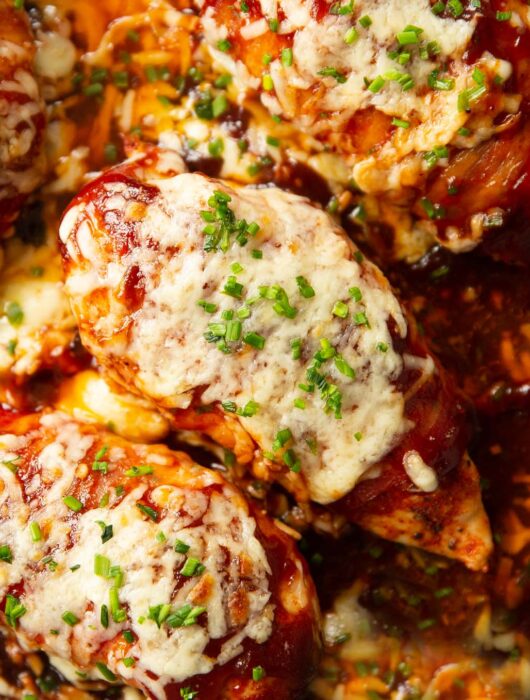 close up overhead shot of hunters chicken in skillet garnished with chives