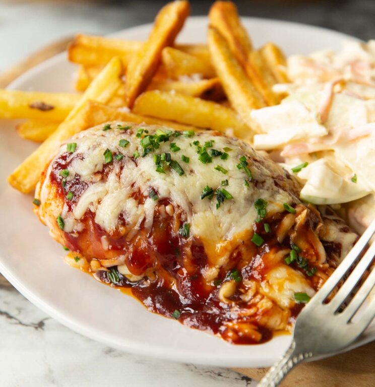 close up shot of hunters chicken on small white plate with chips and coleslaw