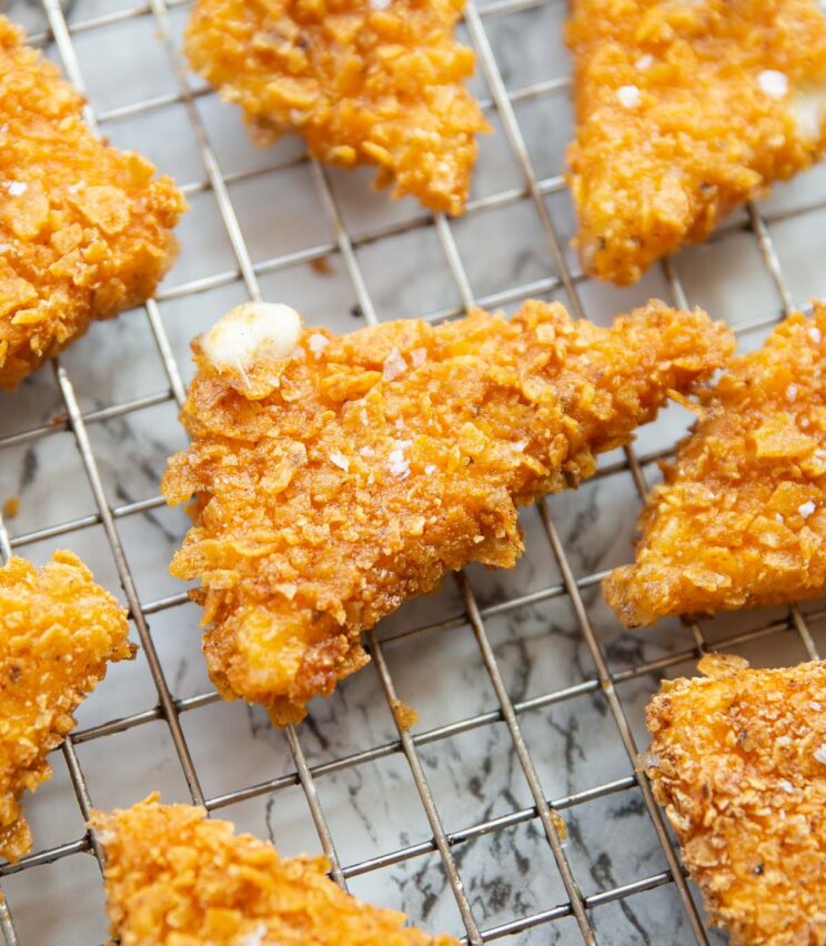close up shot of Dorito crusted cheese triangles on wire rack garnished with sea salt