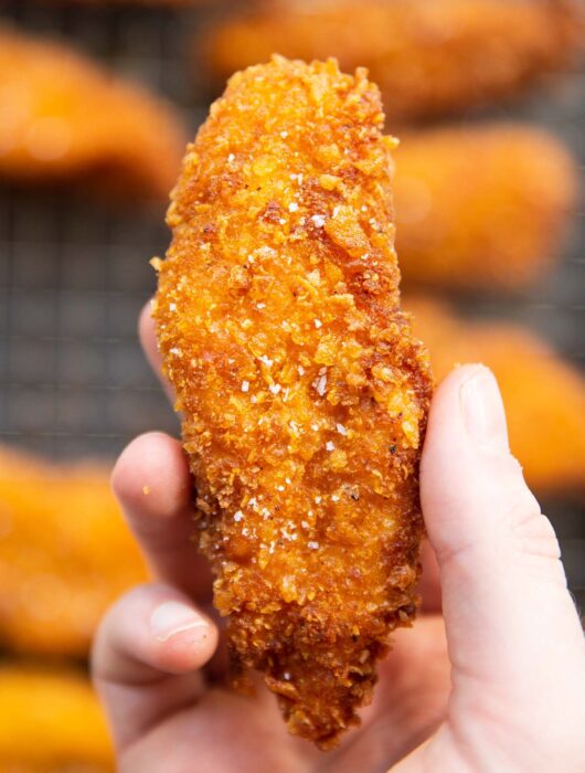 close up overhead shot of hand holding cornflake chicken