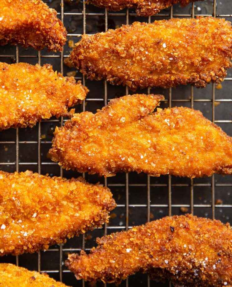 close up overhead shot of cornflake chicken tenders on wire rack