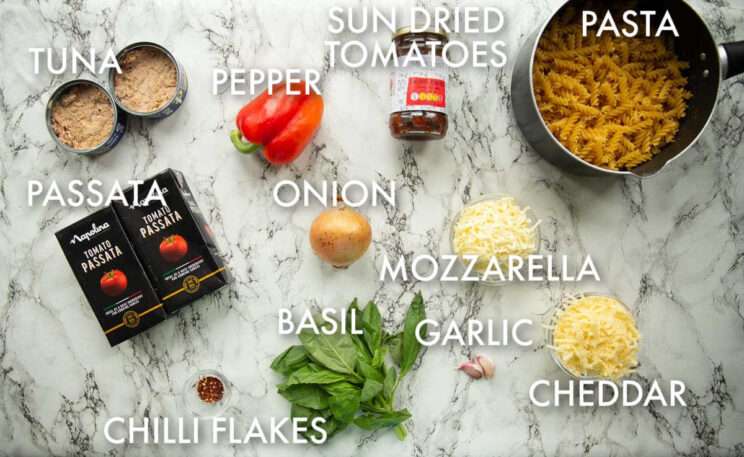 overhead shot of tomato tuna pasta bake ingredients with text labels