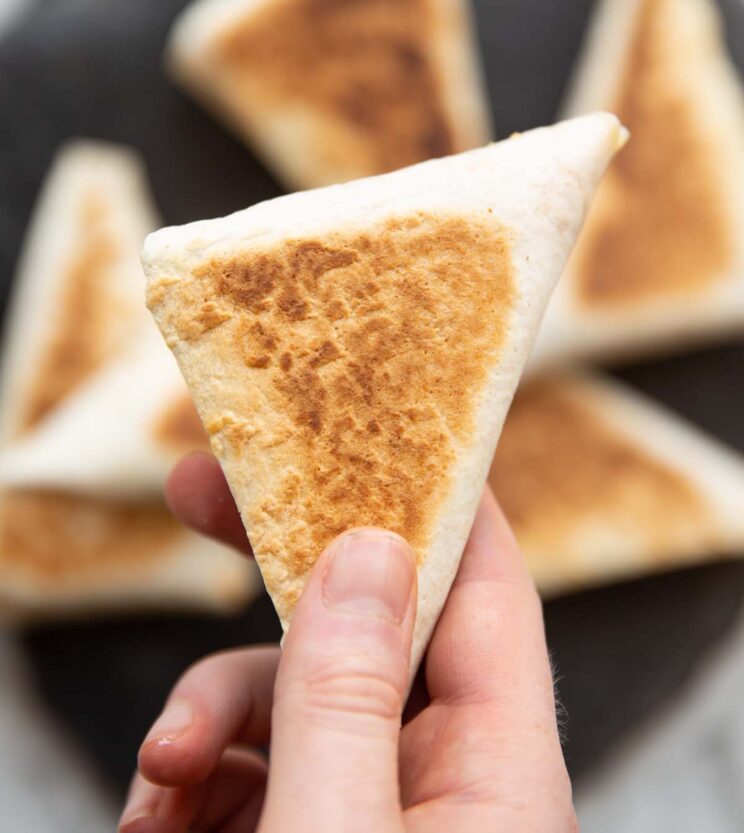 close up overhead shot of hand holding tortilla breakfast parcel