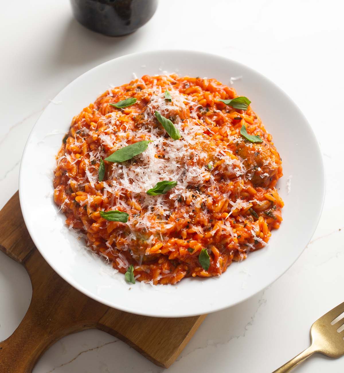 baked chicken meatballs orzo served in white dish on wooden chopping board