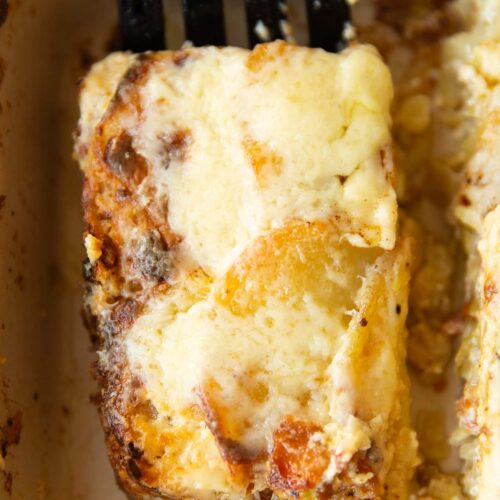 close up overhead shot of black spatula lifting portion of leek bacon potato gratin