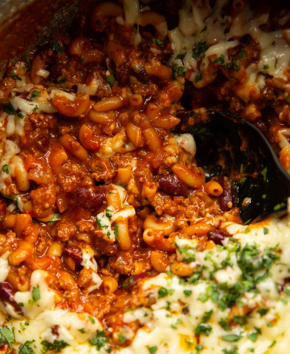 close up shot of serving spoon digging into one pot chili mac